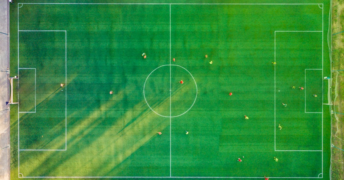 Aerial shot of a soccer game with players on a vibrant green field. ukuran lapangan sepak bola