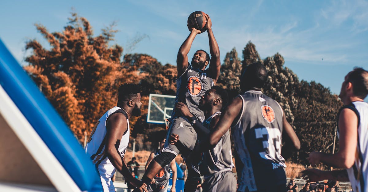 Dynamic basketball players in action during an outdoor game in a sunny park.