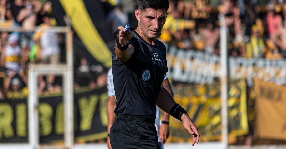 Soccer referee signaling a decision during an intense game outdoors. peraturan sepak bola