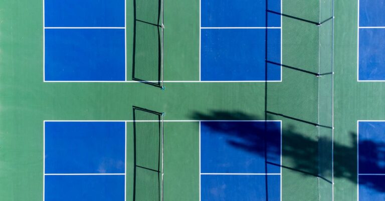 Top-down photo of vibrant blue and green sports courts with nets, perfect for recreational activities.