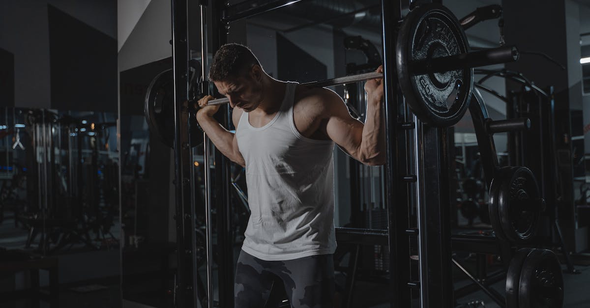 Athletic man in activewear lifting weights at the gym, showcasing strength.