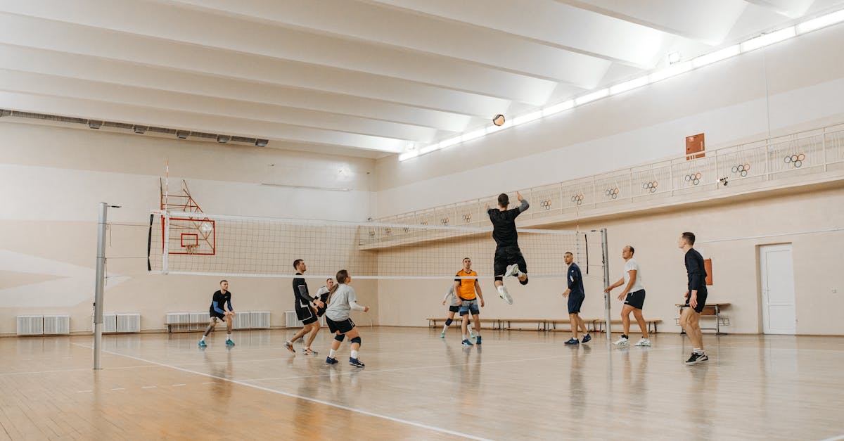 Players in an intense volleyball match indoors, showcasing athleticism and teamwork.