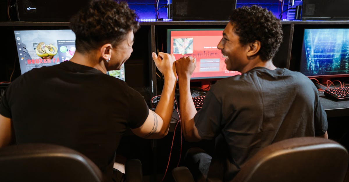 Two male friends enjoying a victory in a gaming competition indoors, showcasing teamwork and friendship.