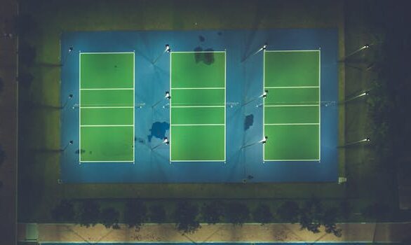 A captivating aerial view of illuminated sports courts at night showcasing patterns and symmetry. gambar lapangan bola voli. gambar ukuran lapangan bola voli