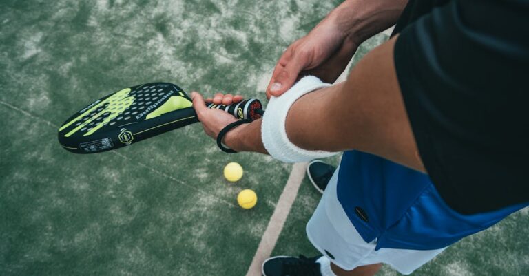 Close-up of a male padel player adjusting wristband on a court. Sports action focused.