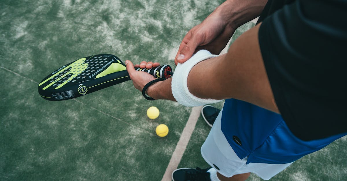 Close-up of a male padel player adjusting wristband on a court. Sports action focused. manfaat olahraga tenis lapangan