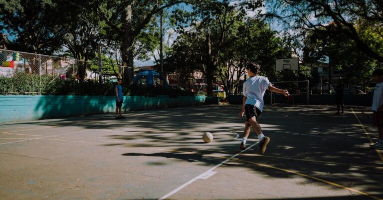 Boys play a casual game of football in a sunlit park in Medellín, Colombia.