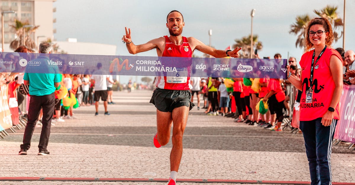 Male runner celebrates crossing the finish line in an outdoor marathon race.