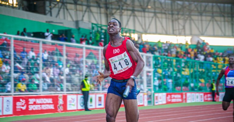 A focused athlete in a relay race at a national sports festival, showcasing determination and speed.