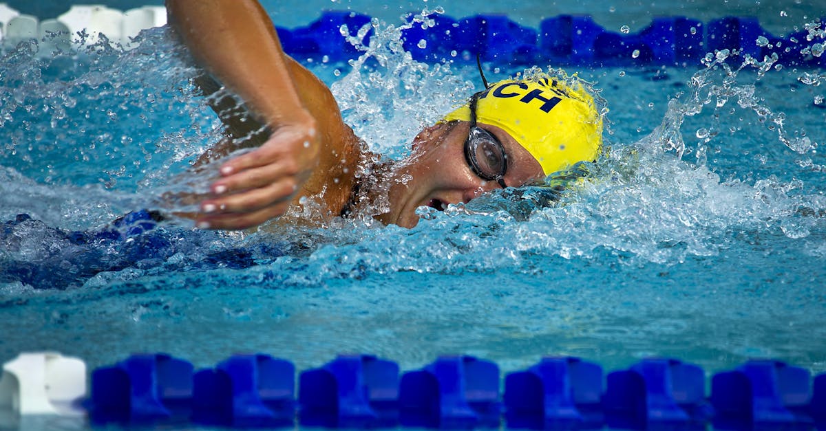 Swimmer wearing a yellow cap and goggles competing in a swimming pool